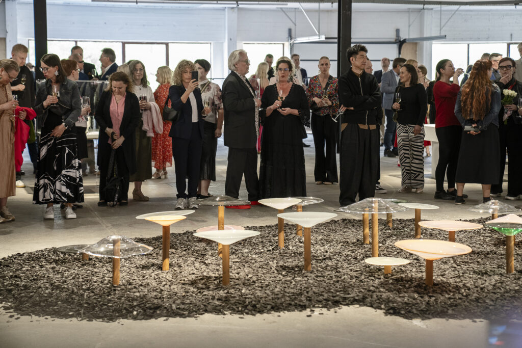 Finnish Glass Biennale 2025 avajaiskuva, jossa ihmisiä ja lasi-installaatio